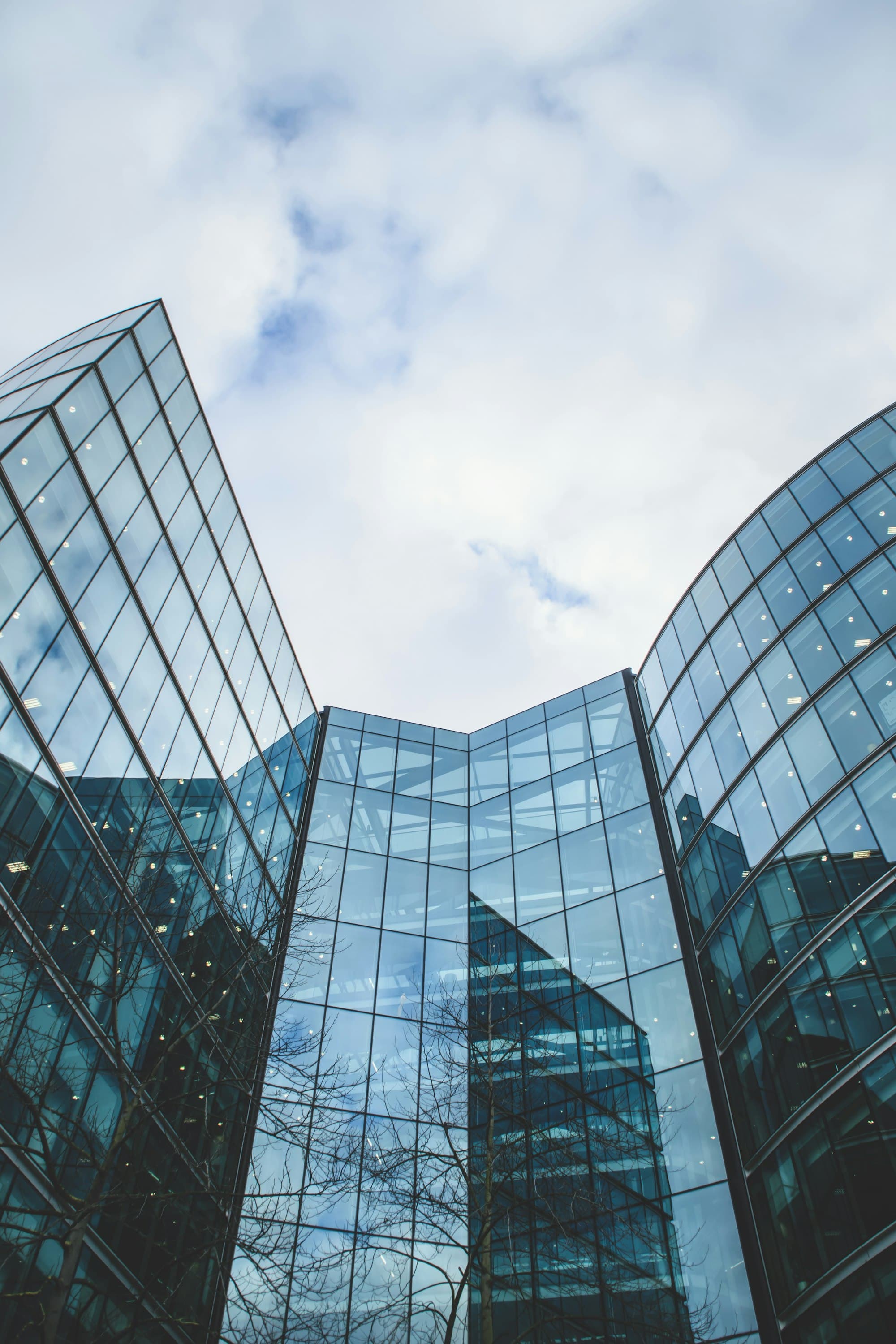 Glass commercial architecture photographed from below against cloud.