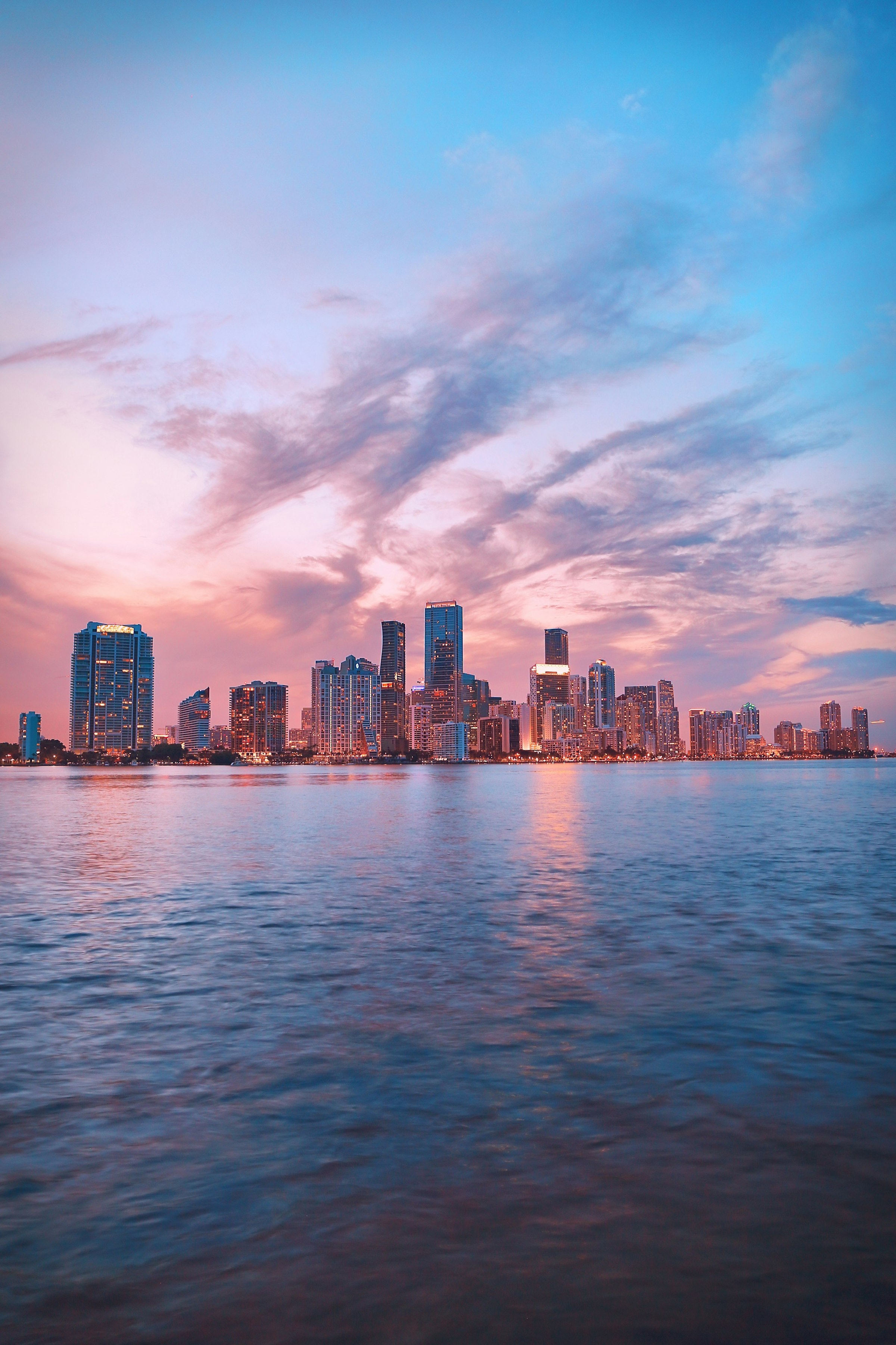 Miami skyline at sunset, with towers along the water under a late sky.